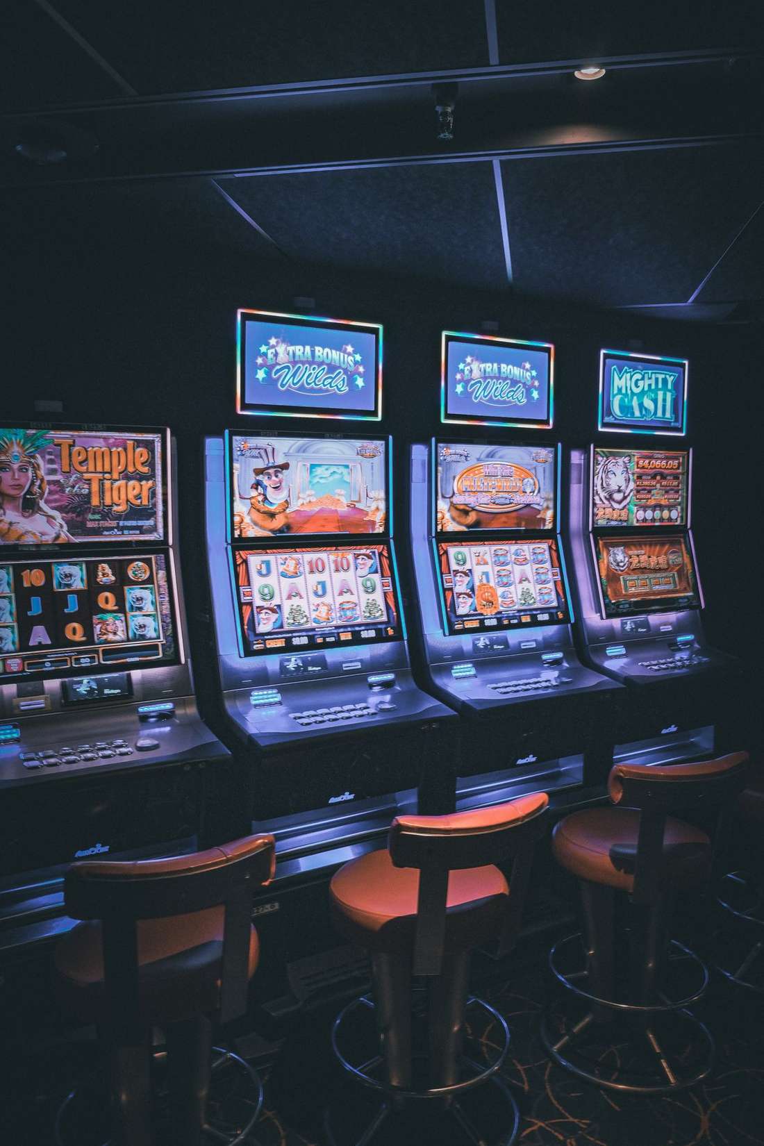 Deretan mesin slot berlampu di lantai kasino
